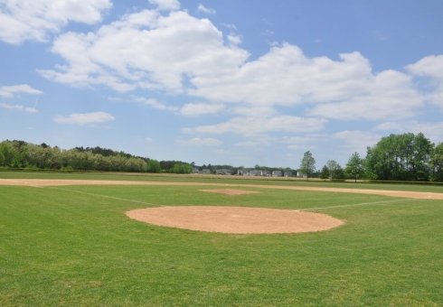 green field and orange dirt baseball field